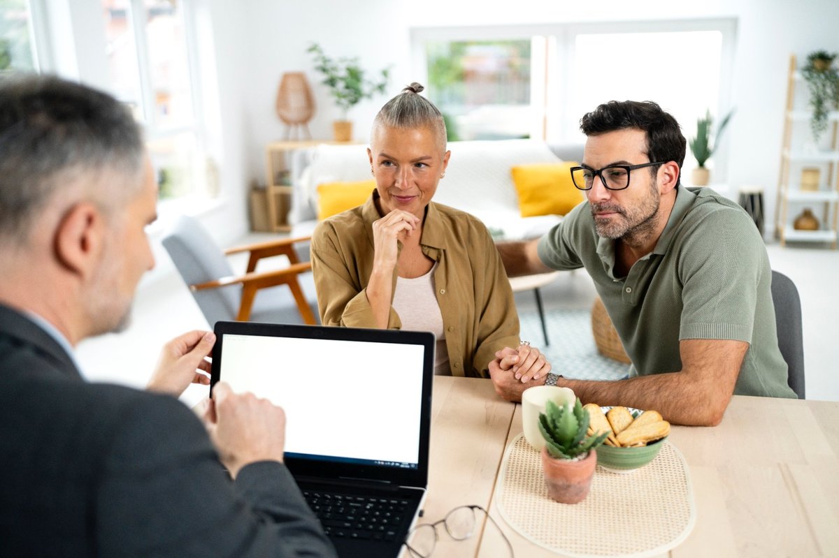 Couple meeting with a financial advisor in a relaxed home setting